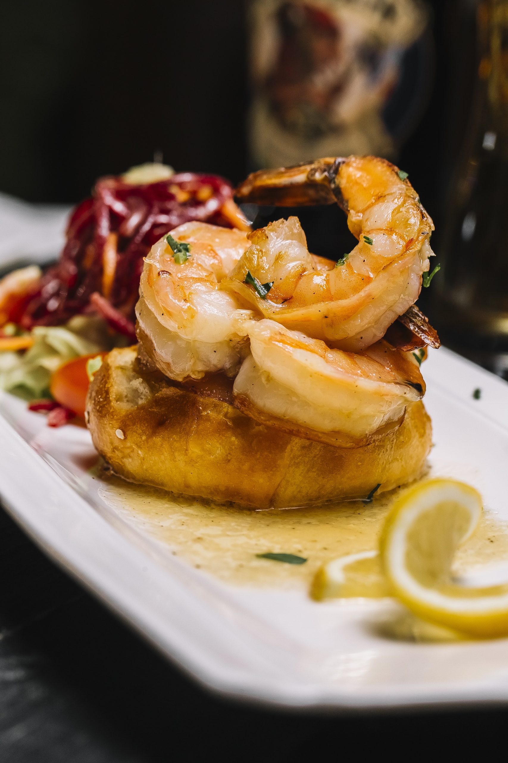 side view shrimp toast with vegetable salad and a slice of lemon